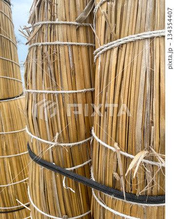Three tall bamboo poles with strings tied to them 134354407