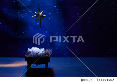 Starry Night Nativity. A nativity scene under a glowing star in a deep blue, starry background Starry Night Nativity. A nativity scene under a glowing star in a deep blue, starry background 134354502