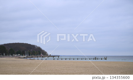 Calm seaside landscape under cloudy sky with minimal human activity Calm seaside landscape under cloudy sky with minimal human activity 134355600