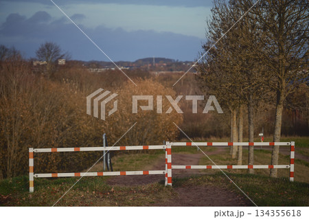 Silent rural road, Old weathered barrier obstructs peaceful lane 134355618