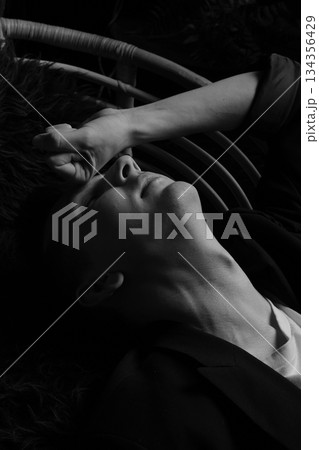 Calm expression highlighted by surrounding plant fronds and soft light 134356429