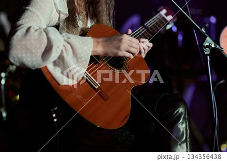 Musician Passionately Performs Heartfelt Song On Stage With Warm Lighting And Intimate Atmosphere 134356438