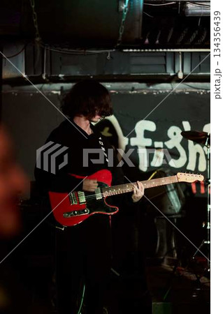Guitarist Tunes Backstage, Artist Prepares Red Electric Guitar Amidst Cables And Ambiance Of Lowlit Venue 134356439