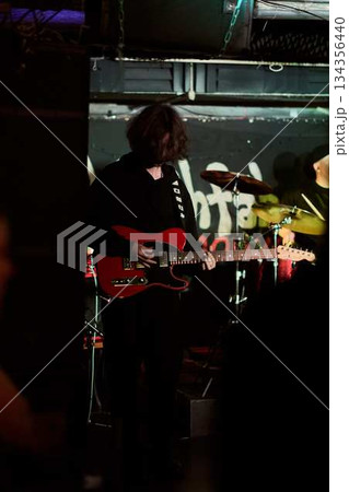 Nighttime Concert Featuring Silhouetted Guitarist With Neon Reflections And Hazy Club Ambiance 134356440