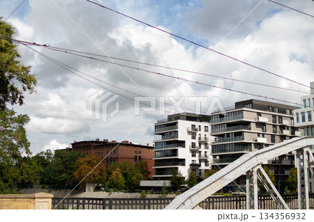 Modern buildings and historical architecture along the river under a cloudy sky 134356932