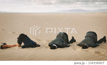 Three people lying on the sand in a desert area during cloudy weather Three people lying on the sand in a desert area during cloudy weather 134356957