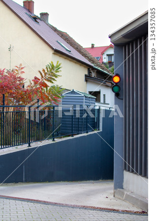 Bright traffic light signals caution near the curved entrance of a small alley Bright traffic light signals caution near the curved entrance of a small alley 134357085