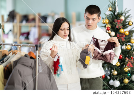couple chooses underwear against the background of a Christmas tree couple chooses underwear against the background of a Christmas tree 134357698
