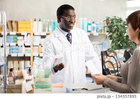 Male pharmacist gives woman prescription pills Male pharmacist gives woman prescription pills 134357895