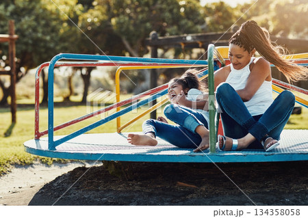 Mother with daughter laughing, together on roundabout at park and playing with fun outdoor. Love, care and bonding with family happiness, woman and girl enjoying time at playground with freedom Mother with daughter laughing, together on roundabout at park and playing with fun outdoor. Love, care and bonding with family happiness, woman and girl enjoying time at playground with freedom 134358058