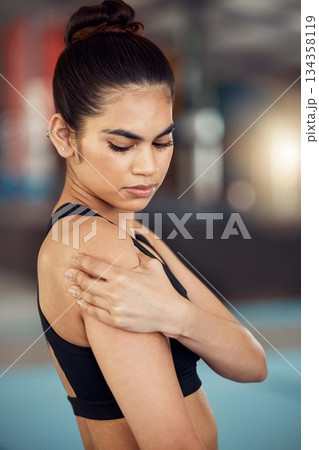 Injury, hurt and shoulder pain for a female athlete holding her painful arm at the gym. Active, fit and athletic woman suffering from muscle inflammation due to an exercise or workout Injury, hurt and shoulder pain for a female athlete holding her painful arm at the gym. Active, fit and athletic woman suffering from muscle inflammation due to an exercise or workout 134358119
