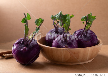 Purple kohlrabi or turnip cabbage in wooden bowl on brown background 134361634