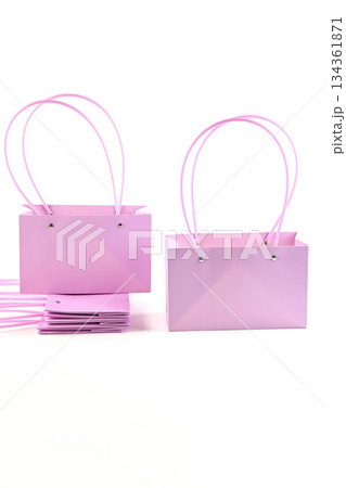 Pastel pink flower bags with handles on white background. Empty paper packaging for bouquets used in flower shops and floral retail display. 134361871