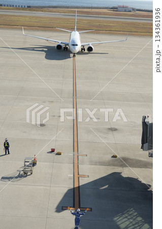 到着した飛行機を誘導するマーシャラー 134361936
