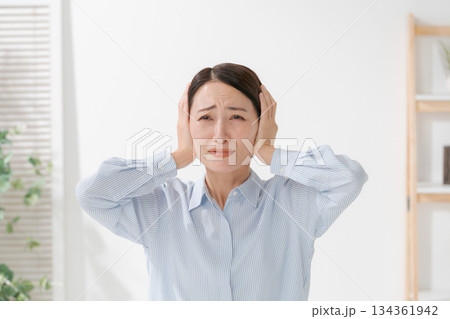 耳を塞ぐ女性 134361942