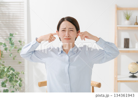 耳を塞ぐ女性 134361943