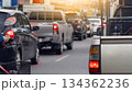Rear side view of pickup car with railings or other items on the truck. With turn on brake light. Traffic jam on the asphalt road at day with many car were queuing in a long line. 134362236
