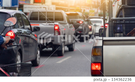 Rear side view of pickup car with railings or other items on the truck. With turn on brake light. Traffic jam on the asphalt road at day with many car were queuing in a long line. Rear side view of pickup car with railings or other items on the truck. With turn on brake light. Traffic jam on the asphalt road at day with many car were queuing in a long line. 134362236