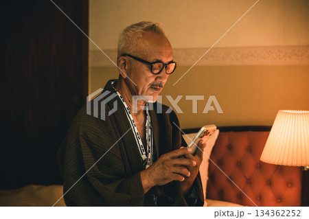 寝室でスマホを見るシニア男性 134362252