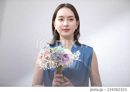 花束を持つ青いブラウスの女性 134362323