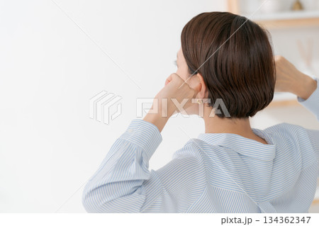 耳を塞ぐ女性の後ろ姿 134362347