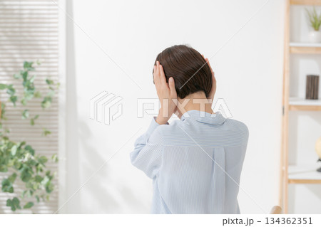 耳を塞ぐ女性の後ろ姿 134362351
