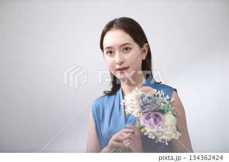 花束を持つ青いブラウスの女性 134362424