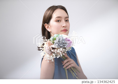 花束を持つ青いブラウスの女性 134362425