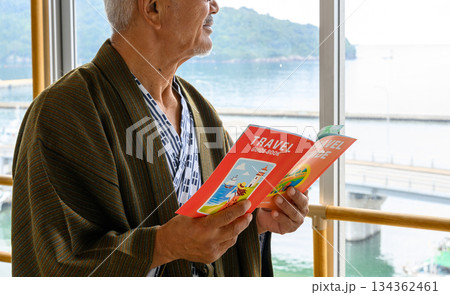 浴衣の男性が観光ガイドブックを読む 浴衣の男性が観光ガイドブックを読む 134362461