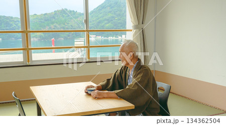 窓辺で海を眺める和服の高齢男性 窓辺で海を眺める和服の高齢男性 134362504