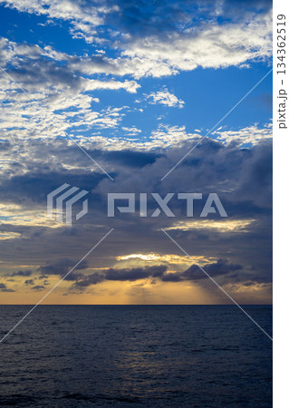 暗雲を割る夕焼けの海と空 暗雲を割る夕焼けの海と空 134362519