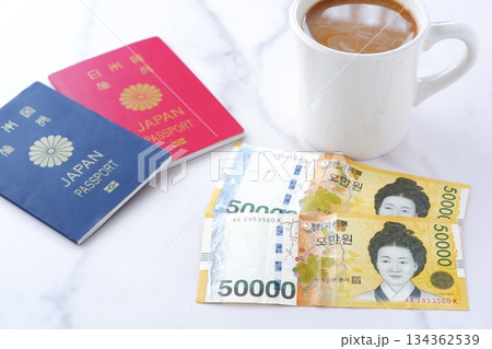 韓国の通貨、ウォンKRWの紙幣(50000ウォン札)とパスポート(10年用赤色と5年用紺色) 韓国の通貨、ウォンKRWの紙幣(50000ウォン札)とパスポート(10年用赤色と5年用紺色) 134362539