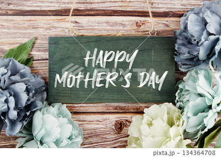 Happy Mother's Day text written on wooden plank with flower decoration on wooden background Happy Mother's Day text written on wooden plank with flower decoration on wooden background 134364708