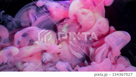 Cloud blend. Ink fluid. Blur pink purple yellow color fume sparkling wave swirling texture spreading on abstract dark black background. Cloud blend. Ink fluid. Blur pink purple yellow color fume sparkling wave swirling texture spreading on abstract dark black background. 134367027