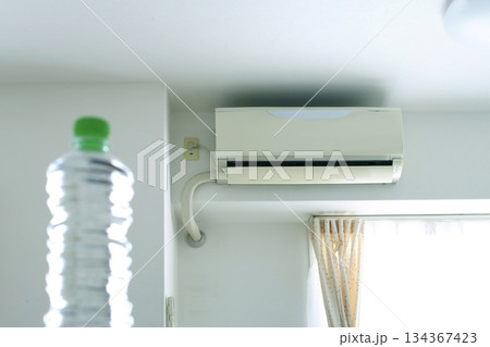 部屋のクーラーとペットボトル 134367423
