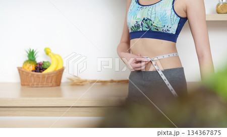 Measuring Waist for Fitness Goals. A person tracking health progress with a tape measure. Measuring Waist for Fitness Goals. A person tracking health progress with a tape measure. 134367875