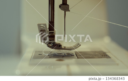 Woman clothing designer sews fabrics on a sewing machine. Needlework and handmade hobby. 134368343