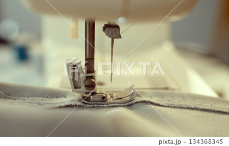 Woman clothing designer sews fabrics on a sewing machine. Needlework and handmade hobby. 134368345