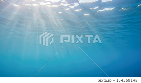 Beautiful underwater background with sun light beams in clear blue ocean, summer nature scene for vacation, diving and serene relaxation concept 134369148