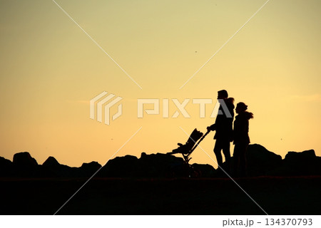 Silhouettes Walking by the Sea at Sunset. Silhouettes Walking by the Sea at Sunset. 134370793