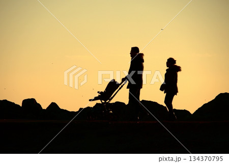 Silhouettes Walking by the Sea at Sunset. Silhouettes Walking by the Sea at Sunset. 134370795