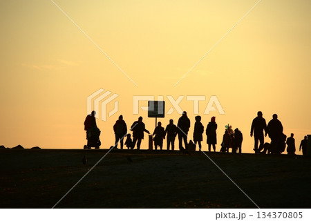 Silhouettes Walking by the Sea at Sunset. Silhouettes Walking by the Sea at Sunset. 134370805