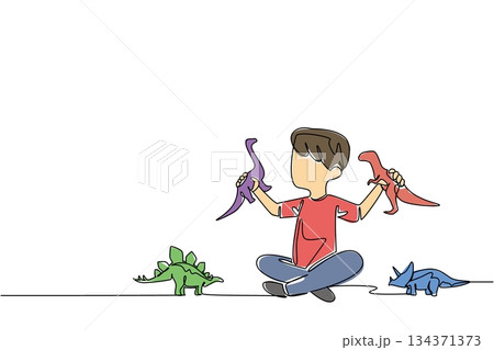 Single one line drawing a boy plays with a dinosaur toy on the floor with each hand holds a toy. Collection of extinct animal toys. Exciting. Dinosaur Day. Continuous line design graphic illustration 134371373