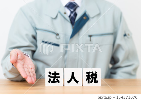 法人税のブロックと作業着を着たミドル男性ビジネスマン 134371670