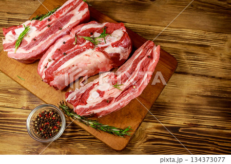 Raw pork ribs with spices and rosemary on wooden table. Top view 134373077