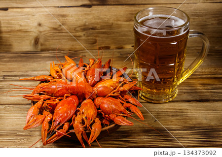Boiled crayfish and mug of beer on a wooden table 134373092