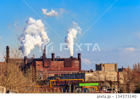 View of old factory with pipes with smoke. Air pollution, environmental damage 134373140