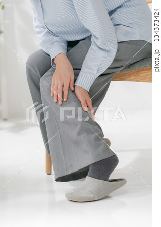 膝を押さえる女性 134373424