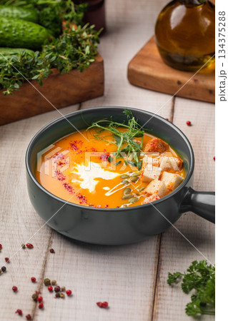 Creamy pumpkin soup with herbs and croutons Creamy pumpkin soup with herbs and croutons 134375288