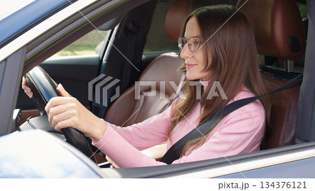 Confident smiling Caucasian woman female driver sitting inside new car.  134376121